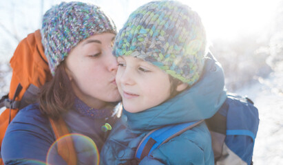 Obraz premium Mom kisses and hugs her son.