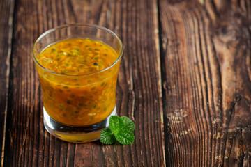 a glass of passion fruit juice place on wooden  floor