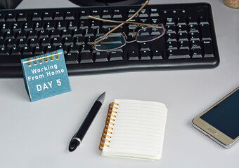 Home office desk with desktop, accessories and text written on blue note. Work from home concept
