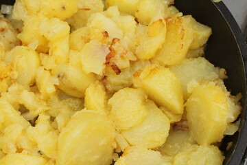 fresh fried potatoes with onions in a pan