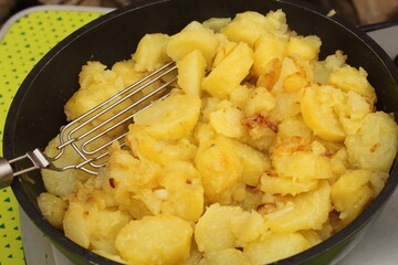 fresh fried potatoes with onions in a pan