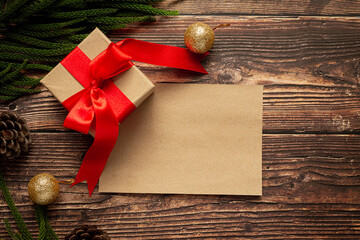 a box of present with red ribbon bow on wooden background