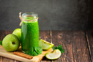 a glass of green apple healthy smoothie put next to fresh green apples