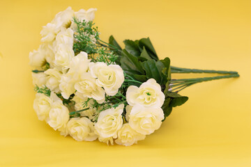An artificial white flower on a yellow background