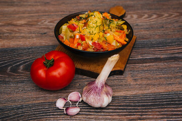 Vegetable stew, vegetarian food. Food made from potatoes, tomatoes and zucchini. A spicy dish with garlic.