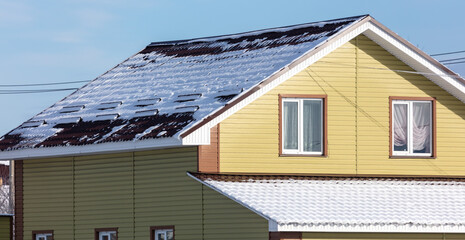 Snow on the roof of the house.