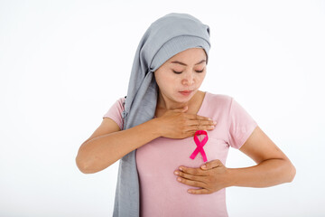 a asian women wearing headscarf disease with pink ribbon hand checking lumps on her breast for...