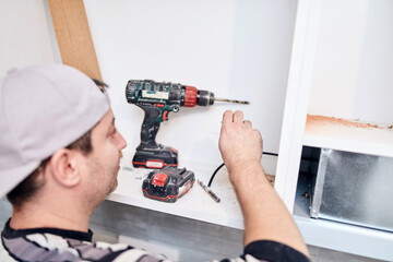 Handyman worker assembling furniture and fixing it.