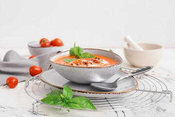 Bowl of tasty tomato cream soup on table