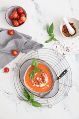 Bowl of tasty tomato cream soup on  light background