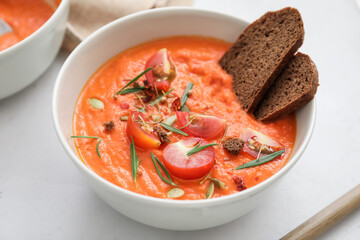 Bowl of tasty tomato cream soup on table