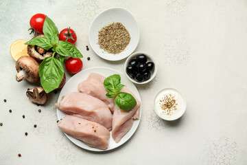 Plate with raw cut chicken fillet some ingredients on light background