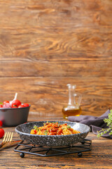 Plate of tasty pasta with chicken and vegetables on wooden table