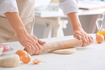 Obraz na płótnie Canvas Woman making raw pasta in kitchen, closeup