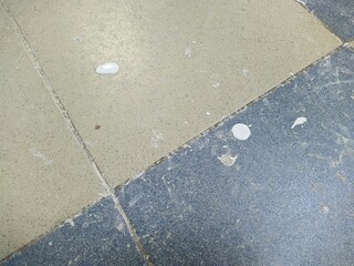 drops of white paint indoors on the floor where repairs are in progress