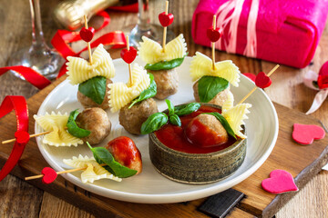 Valentines day or birthday romantic dinner. Pasta cooked in the form of canapes, meatballs, served with tomato sauce.