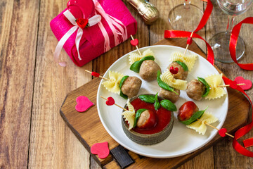 Valentines day or birthday romantic dinner. Pasta cooked in the form of canapes, meatballs, served with tomato sauce. Copy space.