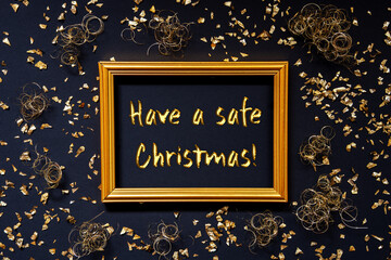 Frame With English Text Have A Safe Christmas. Golden Christmas Decoration And Ornament. Black Background With Glitter And Sparkle
