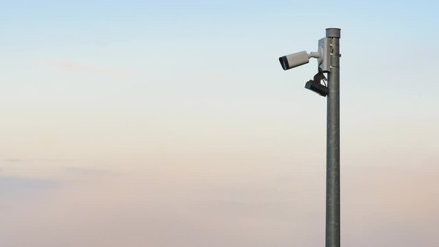 Security camera cctv video surveillance against sky with clouds moving across it. Time lapse.