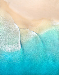 Beautiful aerial view of blue pristine water with surfers and gentle waves