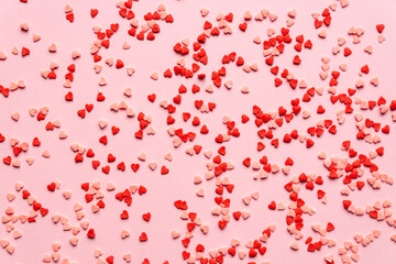 Fototapeta na wymiar sprinkles background, sugar sprinkle red hearts, decoration for cake and bakery. Top view, flat lay. Valentines holiday