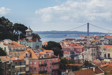 Fototapeta na wymiar Lisbon. Bridge and Jesus Christ in background. Rooftops. Sunny spring day.
