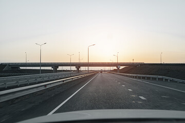 Fototapeta na wymiar Empty highway at dawn, view from driver's perspective