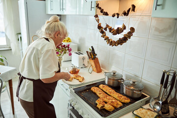 Lovely old woman placing meat pie on plate