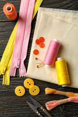 Sewing supplies on wooden background, top view