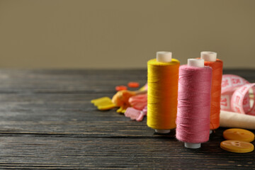 Sewing supplies on wooden background, space for text