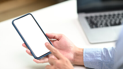 Close up view of male hands typing on mobile phone with white empty space for advertise text.