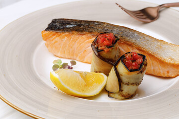 Roasted salmon fillet in plate on white wooden table