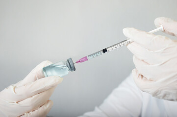 Doctor or nurse holding syringe vaccine testing and prepares for injection,medicine and drug concept.