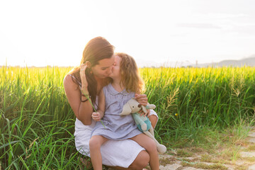 Young Mother and daugther Hug near rice field, nature, travel