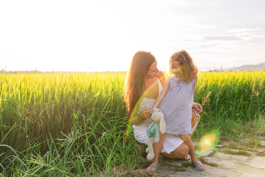 Young Mother and daugther Hug near rice field, nature, travel