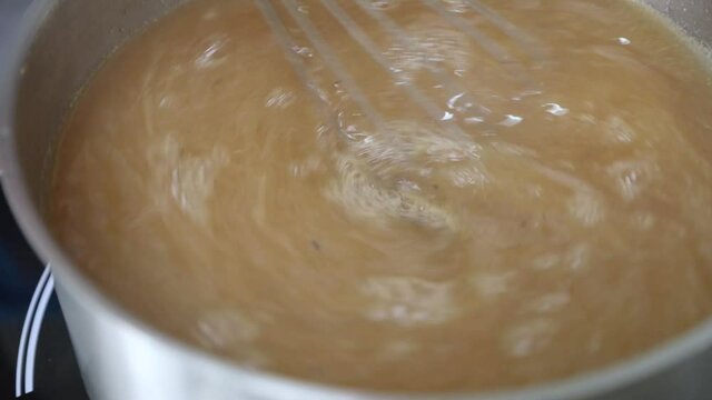 Whisking And Cooking Apple Jam On Stainless Steel Pot. - close up, high angle