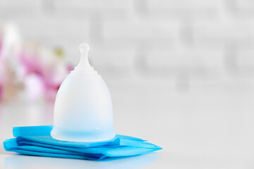 Menstrual cup and hygienic pad on table close up