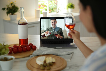 Friends drinking wine while communicating through online video conference in kitchen. Social...