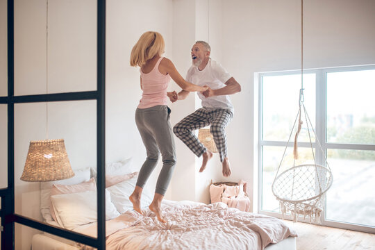 Mature Couple Jumping On The Bed And Feeling Awesome