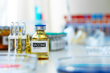 Vaccine in vial for injection on table against background of laboratory
