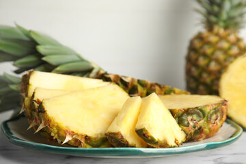 Plate with tasty cut pineapple on table, closeup