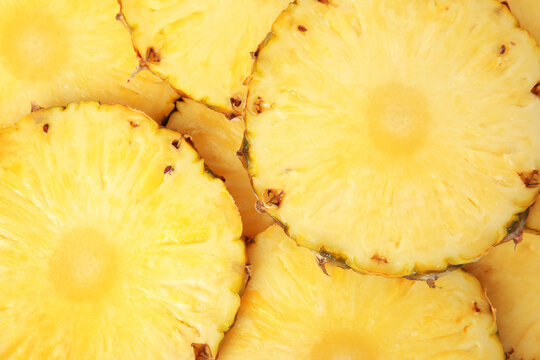 Slices of tasty ripe pineapple as background, top view