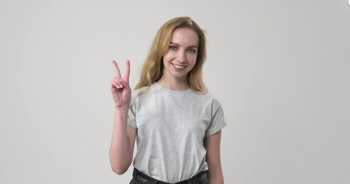 Happy woman giving v hand sign over white background