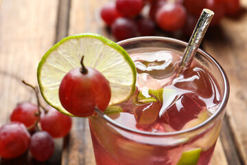 Soda water with grapes, ice and lime, closeup. Refreshing drink
