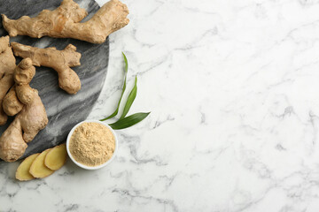 Dry ginger powder, fresh root and leaves on white marble table, flat lay. Space for text