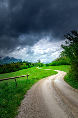 Fototapeta na wymiar Mountain path. Green hills and cloudy skies. Slovenia