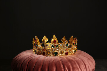 Beautiful golden crown on pink velvet pillow. Fantasy item