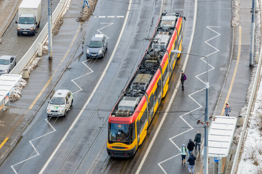Widok na tramwaj na przystanku tramwajowym Pl. Zamkowy w Warszawie. Wiko z wieży kościoła Ś.w. Anny.