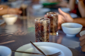 Blurred abstract background of hands eating on a table like seafood (Baked shrimp vermicelli, deep fried sea bass with fish sauce, yum squid) eaten alongside soft drinks, while on vacation with family