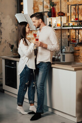 Sensual couple in love drinks champagne in the kitchen. Romantic holiday for a young couple in love.